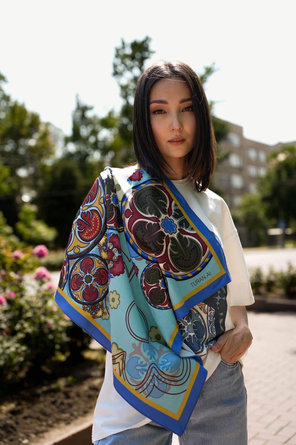 TURANAI silk scarf with Kyrgyz ornament in blue and ochre draped over a model’s shoulders