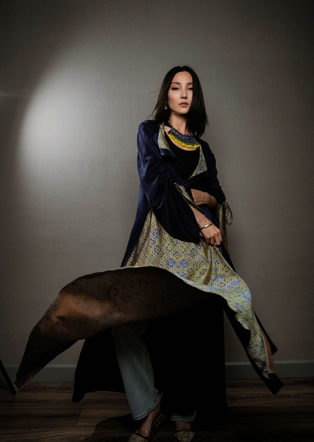 Model in a deep blue velvet TURANAI chapan worn over an ornamented dress